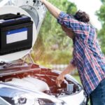 Automobilista apre cofano auto e batteria scarica