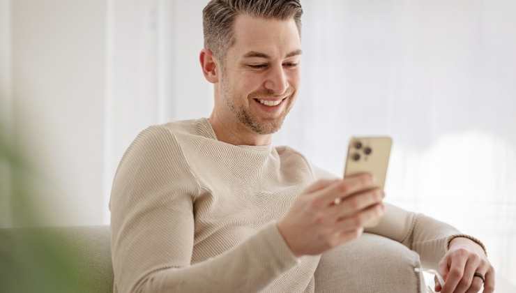 ragazzo sorridente guarda cellulare